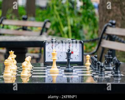 Nahaufnahme des Schachs und eine Uhr im Washington Square Park in New York City Stockfoto