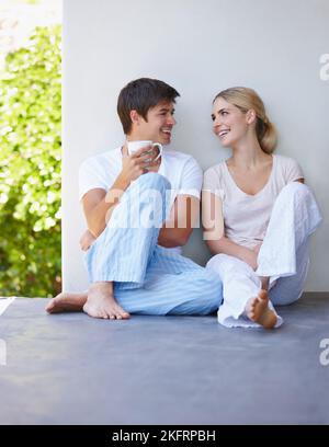 Wir gehen zusammen wie Kaffee und Creme. Ein glückliches junges Paar verbringt am Morgen einige Zeit zusammen auf der Terrasse. Stockfoto