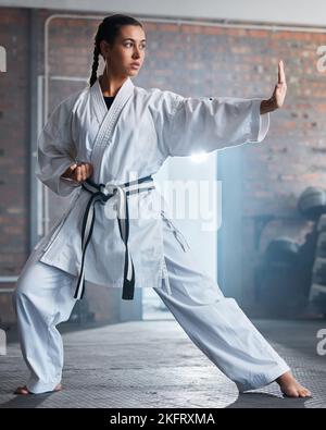 Karate-Training, Fitness und Frau im Fitnessstudio, Gesundheitsmotivation und starker Fokus für Kampftraining. Faust, Sport und gesunde Sportler Person Stockfoto