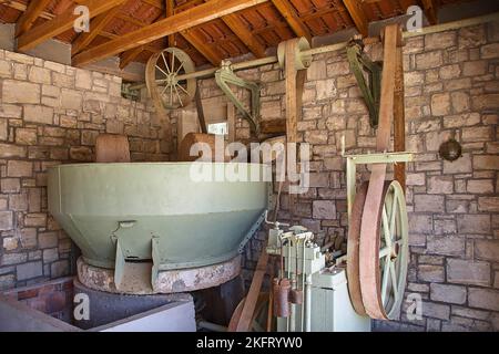 Oliven (olivae), Olivenölfabrik, Ölmühle, Olivenpresse, grünes Metallfass, Radwerk, Holzdach, Steinmauer, Insel Kreta, Griechenland, Europa Stockfoto