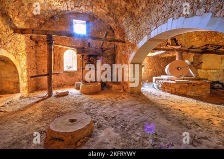 Oliven (olivae), Olivenölfabrik, Olivenölmühle, alte Olivenmühle, alte Wandgewölbe, Mühlsteine, Fenster, Hintergrundbeleuchtung, Gavalochori, Drapanon Peninsula, Cr Stockfoto