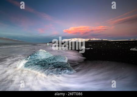 Diamond Beach, Eisberge am schwarzen Lavastrand, an der Jökulsarlon Gletscherlagune, Sonnenaufgang, Vatnajökull Nationalpark, Hornafjörður, Südisland, Island, Stockfoto