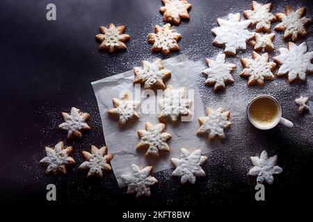 Blick von oben auf einige Weihnachtskekse, die von Mehl umgeben sind Stockfoto