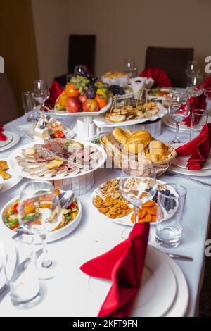 Ein Tisch voller verschiedener Gerichte. Obst, Snacks und Desserts auf der Veranstaltung Stockfoto