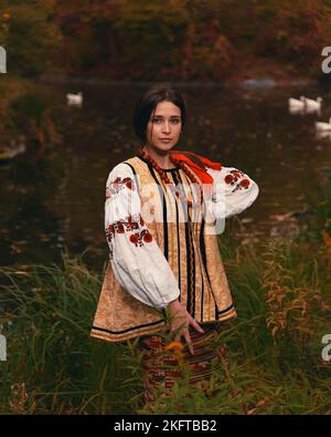 Junge Frau trug traditionelle bestickte ukrainische Kleidung. Porträt eines schönen selbstbewussten Mädchens mit langen dunklen Haaren und braunen Augen Stockfoto