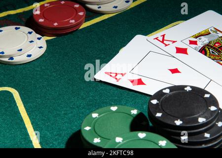 Horizontales Foto. Poker-Karten auf einem grünen Tisch mit Chips. Stockfoto