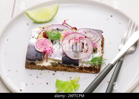 Eingelegter Hering Smorrebrod, dänisches Sandwich mit offenem Gesicht Stockfoto