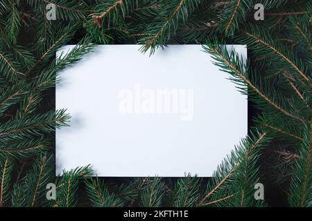 Kreatives Layout aus Christbaumzweigen mit Papierkartennotiz. Konzept für das neue Jahr der Natur. Stockfoto