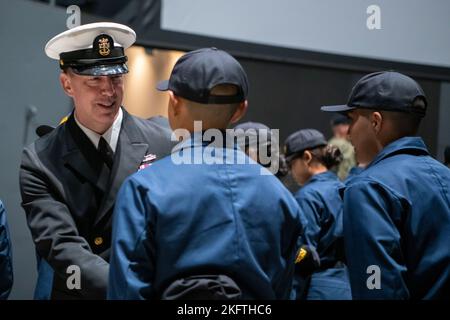 Force Master Chief Jason Dunn, Force Master Chief, Commander Navy Installations Command, gratuliert den Matrosen nach ihrer Deckungszeremonie auf dem Pier der USS Trayer (BST 21) beim Recruit Training Command. Trayer, besser bekannt als „Kampfstationen“, ist das Schmelztiegel-Ereignis, das Rekruten vor ihrem Abschluss passieren müssen und ihr Wissen und ihre Fähigkeiten in grundlegenden Seemannschaft, Schadenskontrolle, Brandbekämpfung, Wachdienst und Notfallmaßnahmen testen müssen. Mehr als 40.000 Rekruten trainieren jährlich im einzigen Bootcamp der Marine. Stockfoto