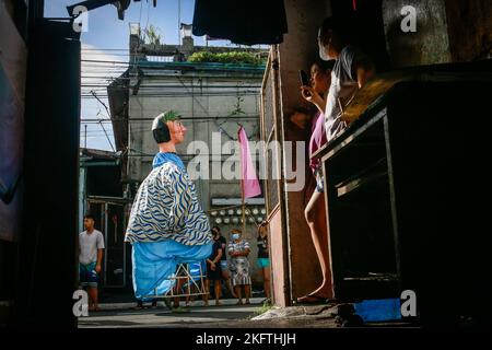 Angono, Philippinen, 20/11/2022, während der großen Parade des Higantes-Festivals fotografieren die Bewohner Papiermaché-Statuen auf den Straßen. Die Einheimischen feiern das Fest ihrer Stadt zum ersten Mal nach zwei Jahren der Suspendierung aufgrund der Pandemie. Die Higantes- oder Pappmaché-Giganten wurden zuerst als eine Form des Protests gegen ihre Gutsbesitzer während der spanischen Kolonisationszeit von lokalen Bauern gemacht. Die riesigen Pappmaché-Puppen messen einen Durchmesser von vier bis fünf Fuß und eine Höhe von zehn bis zwölf Fuß und können die Riesen nur von innen aus kontrollieren. Stockfoto