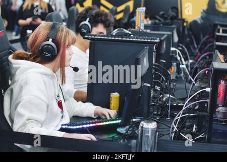 TA'Qali, Malta - 5 2022. November: Eine Gamer-Frau, die auf einer Gaming-Convention Netzwerk-Videospiele mit anderen Spielern spielt Stockfoto