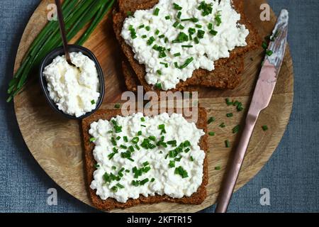 Offene Sandwiches mit Roggenbrot und weißem Quark mit grünen Zwiebeln. Gesundes Frühstück oder Snack. Stockfoto