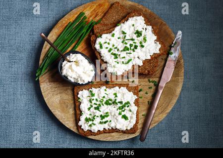 Offene Sandwiches mit Roggenbrot und weißem Quark mit grünen Zwiebeln. Gesundes Frühstück oder Snack. Stockfoto