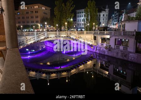 Berühmte drei Brücken am Preseren-Platz im Zentrum von Ljubljana, in der Nacht bunt beleuchtet, Slowenien Stockfoto