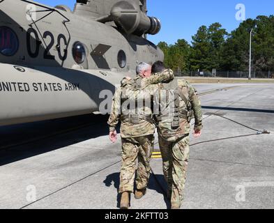 Chief Warrant Officer 5 Scott E. Moore Sr., ein CH-47 Instructor Pilot bei Firma B, 1. Bataillon, 223d Aviation Regiment, und sein Sohn, 2. LT. Scott E. Moore Jr., umarmen sich, als sie sich dem Hubschrauber in Fort Rucker für einen Trainingsflug am 7. Oktober 2022 nähern. Stockfoto