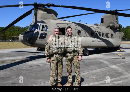 Chief Warrant Officer 5 Scott E. Moore Sr., ein CH-47 Chinook Helikopter Instructor Pilot bei Firma B, 1. Bataillon, 223d Aviation Regiment, Und 2. LT. Scott E. Moore Jr., ein Schüler der Flugschule Chinook, stehen vor einem Trainingsflug am 7. Oktober 2022 für ein Foto in Fort Rucker. Stockfoto