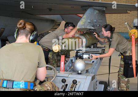 US Air Force Staff Sgt. Janey Sawmiller (rechts), Senior Airman Ross Hall (Mitte), und Airman 1. Class Theresa Calvert (links), 309. Maintenance Unit Maintainer, verwenden einen Waffenstopper, um einen GBU-12 Paveway II während eines Waffenlastwettbewerbs am 7. Oktober 2022 auf der Luke Air Force Base, Arizona, zu laden. Lastwettbewerbe dienen als eine der letzten Auswertungen für vierteljährliche Auszeichnungen im Bereich der Waffenkarriere. Stockfoto