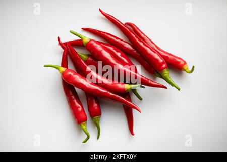 Rote Chilischoten, scharfe und würzige Küchenzutat auf weißem Hintergrund. Stockfoto