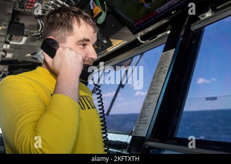 221008-N-WU964-1074 SEA OF JAPAN (8. Oktober 2022) Lt. Cmdr. Joshua Bryan aus Port Charlotte, Florida, kommuniziert mit Piloten aus der Hauptflugkontrolle an Bord des einzigen Flugzeugträgers der US Navy, USS Ronald Reagan (CVN 76), im japanischen Meer, 8. Oktober. Ronald Reagan, das Flaggschiff der Carrier Strike Group 5, stellt eine kampfbereite Truppe zur Verfügung, die die Vereinigten Staaten schützt und verteidigt und Allianzen, Partnerschaften und kollektive maritime Interessen in der indopazifischen Region unterstützt. Air Department, unter Deck, CVN 76, USA Navy, USS Ronald Reagan, Flieger, Stockfoto