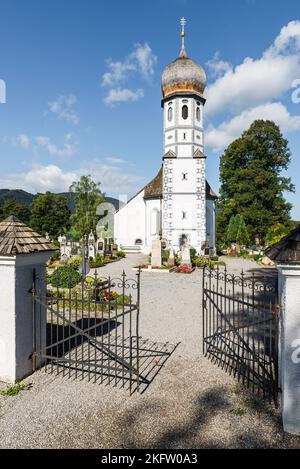 Die barocke katholische Kirche zum Schutz der Jungfrau Maria, umgeben von Gräbern des Friedhofs Fischbachau, Bayern, Deutschland Stockfoto