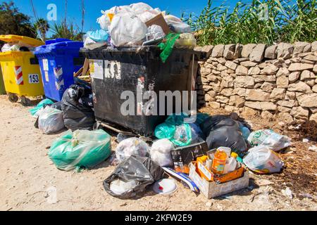 Überfließender Müll in kommunalen Mülltonnen am Straßenrand Siziliens Stockfoto