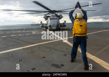 Ryan Akerson, ein Bootsmann-Partner auf dem US-Marinestützschiff Sacagawea, leitet eine CH-53E Super Stallion Marine Heavy Helicopter Squadron 361, Marine Aircraft Group 16, 3. Marine Aircraft Wing, auf das Landedeck der U.S.N.S Sacagawea im Kushiro Port, Japan, 8. Oktober 2022. Die U.S.N.S Sacagawea dient als Kommandooperationszentrum für das Combat Logistics Regiment 37 und bietet logistische Unterstützung für verschiedene Einheiten, die an Resolute Dragon teilnehmen. Resolute Dragon 22 ist eine jährliche Übung zur Stärkung der Verteidigungsfähigkeit des US-japanischen Bündnisses durch die Ausübung von Integrat Stockfoto