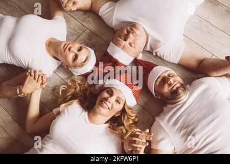 Lächelnde Männer und Frauen halten die Hände und posieren vor der Kamera Stockfoto