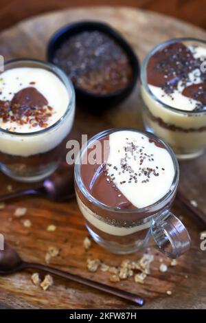 Gesunde Desserts in Tassen. Pudding aus Vanille und Schokolade mit Chiasamen und Leinsamen. Stockfoto