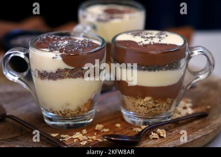 Gesunde Desserts in Tassen. Pudding aus Vanille und Schokolade mit Chiasamen und Leinsamen. Stockfoto