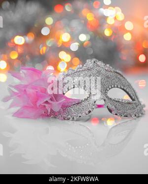 Eine Maske, die auf einem weißen Hintergrund mit verschwommenem Licht über dem Gesicht platziert wird Stockfoto