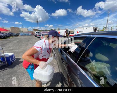 Fort Myers, FL (Okt 11, 2022) - Freiwillige des Roten Kreuzes verteilen Essen in einem Verteilzentrum, das auf dem Parkplatz der Cornerstone Ministries eingerichtet ist. Stockfoto