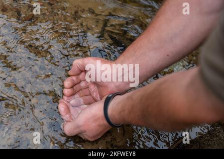 Farmers Checking Water Quality of a Stream in a field, Northumberland, UK. Stockfoto