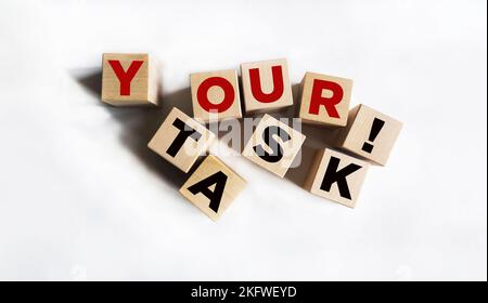 Text DEINE AUFGABEN auf Holzblöcken und weißem Hintergrund Stockfoto