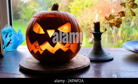 Innenaufnahme eines halloween-Kürbiss und einer Kerze in einem Fenster - John Gollop Stockfoto