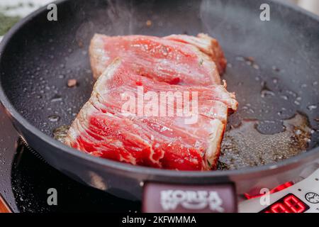 Rohes Rinderfleisch zum Kochen von Steak. Rohes Rindfleisch wird in Scheiben geschnitten, und in einem Kochkurs wird Fleisch zum Kochen von Steak gekocht. Steak-Minion. Selbstgemacht. Stockfoto