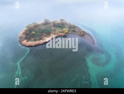 Eine Luftaufnahme einer giftigen blaugrünen Algenblüte (Cyanobakterien), die um eine Insel, Loch Leven, Schottland, wirbelt Stockfoto