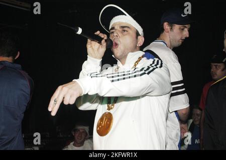 GOLDIE LOOKIN CHAIN, KONZERT, 2003: Adam Hussain bei einem sehr frühen Goldie Lookin Chain Auftritt, bevor er am 18. September 2003 für ihren großen Plattenvertrag im Welsh Club in Cardiff, Wales, Großbritannien unterschrieb. Foto: ROB WATKINS. INFO: Goldie Looking Chain ist eine walisische Comedy-Rap-Gruppe, die 2003 gegründet wurde. Bekannt für ihre humorvollen Texte und unverwechselbaren Persönlichkeiten, erlangten sie mit Hits wie „Guns Don't Kill People, Rapper Do“ und ihrer satirischen Interpretation der britischen Hip-Hop-Kultur Berühmtheit. Stockfoto