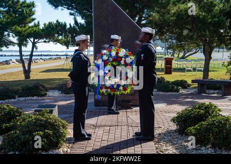 221012-N-CY569-0003 NORFOLK, Virginia (12. Oktober 2022) Seeleute, die dem Arleigh-Burke-Zerstörer USS Cole (DDG 67) zugeordnet sind, stellen einen Kranz am USS Cole Memorial ab. Ehemalige und gegenwärtige Mitglieder der Cole-Crew versammelten sich zusammen mit Familien und Gästen an der Gedenkstätte an Bord der Marinestation Norfolk, um den 22. Jahrestag des Bombenanschlags am 12. Oktober 2000 zu feiern. Cole, DDG, Memorial, USN, Stockfoto