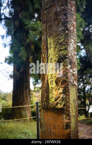 Steindenkmal mit geschnitzten japanischen Wörtern im Waldschrein in Japan Stockfoto