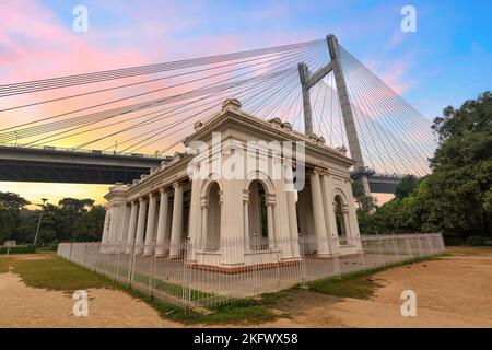 Denkmalgeschützte Architektur im Kolonialstil im Princep Ghat Kolkata, Indien, mit Blick auf die Vidyasagar Setu-Seilbahn, die bei Sonnenaufgang die Brücke hielt Stockfoto