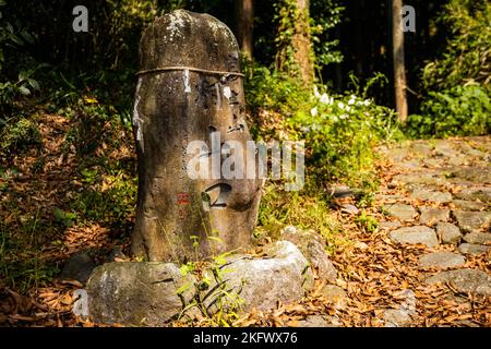 Steindenkmal mit geschnitzten japanischen Wörtern im Waldschrein in Japan Stockfoto