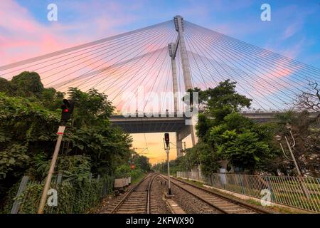 Leere Bahngleise mit Blick auf die Brücke Vidyasagar Setu bei Sonnenaufgang in der Nähe von Princep Ghat in Kalkutta, Indien Stockfoto