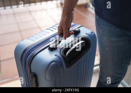 Touristenfrau, die bei der Ankunft in ihrer Ferienwohnung einen Koffer zieht. Stockfoto