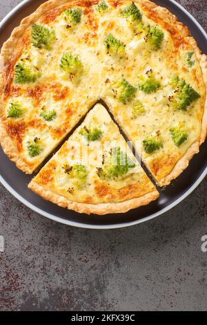 Offener Kuchen mit frischem Romanesco-Brokkoli, Eiern und Käse in Nahaufnahme auf einem Teller auf dem Tisch. Vertikale Draufsicht von oben Stockfoto