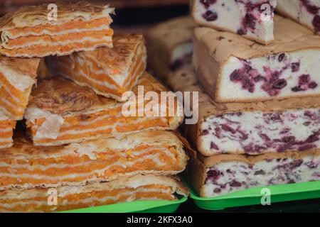 Details zur geringen Schärfentiefe (selektiver Fokus) mit traditionellem rumänischen Kürbiskuchen und Sauerkirschkuchen. Stockfoto