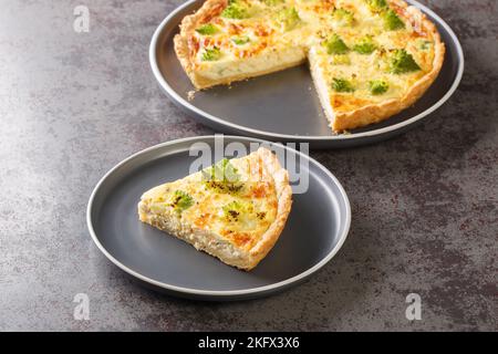 Gebackene Gemüsequiche mit romanesco-Brokkoli, Eiern und Käse in Nahaufnahme auf einem Teller auf dem Tisch. Horizontal Stockfoto