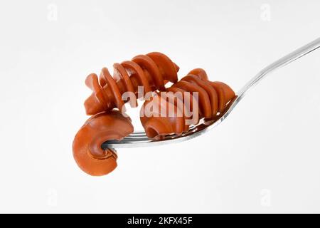 Nahaufnahme von Kaffeepasta auf einer Gabel auf weißem Hintergrund Stockfoto