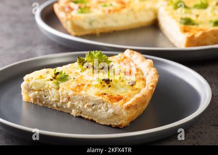 Traditionelle Gemüsequiche mit romanesco Brokkoli und Käse in Nahaufnahme auf einem Teller auf dem Tisch. Horizontal Stockfoto