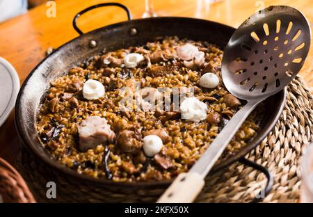 Köstlicher katalanischer Bergreis mit Pilzen und Schweinefüßen Stockfoto