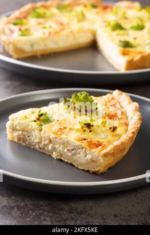 Romanesco-Kohltorte mit Käse und Eiern in der Nähe auf dem Teller auf dem Tisch. Vertikal Stockfoto